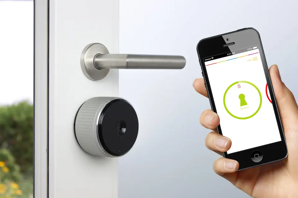 Elektronisches Türschloss an einer Wohnungstür, das per Smartphone-App geöffnet wird