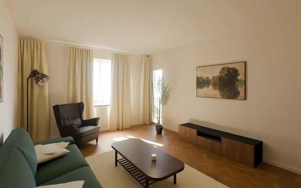 Helles Wohnzimmer mit Fischgrätparkett, grünem Sofa und Ohrensessel